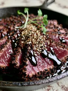 Extreme close-up of thick sliced ahi tuna with a dark blackened crust and rare pink center. (Blackened Balsamic Tuna Steaks)