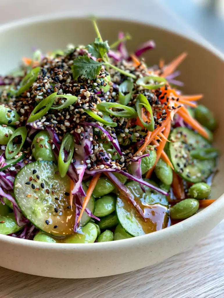 Japanese edamame salad garnished with black and white sesame seeds and fresh cilantro.