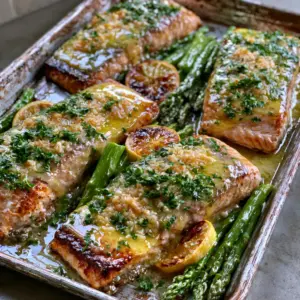 Thick Atlantic salmon fillets with a golden-brown seared crust and translucent garlic butter glaze. (Baked Lemon Garlic Butter Salmon)