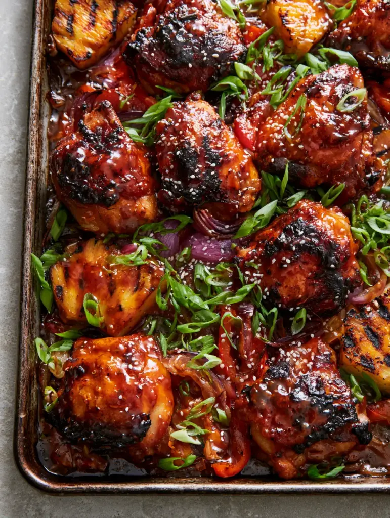 Huli Huli Chicken Recipe: The Ultimate Sticky Hawaiian Sheet Pan Feast 1 Close up of caramelized chicken thighs with grill marks, purple onion petals, and bias-cut green scallions. (Huli Huli Chicken)