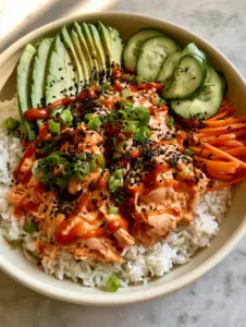 A handheld smartphone photo of a vibrant spicy tuna bowl featuring glossy orange tuna and fresh vegetables. (spicy tuna bowl)