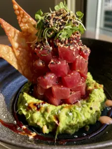 High-angle photo of tuna tartare showing the distinct cubes of fish and glossy sesame soy glaze.